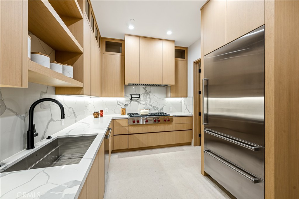 25079 Jim Bridger Road Hidden Hills, CA 91302 - Photo 27 of 73 a kitchen with stainless steel appliances kitchen island a refrigerator sink and cabinets
