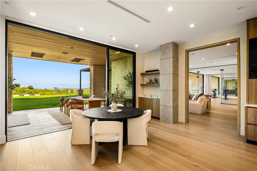 25079 Jim Bridger Road Hidden Hills, CA 91302 - Photo 28 of 73 a dining room with furniture and a floor to ceiling window
