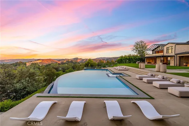 a view of a house with pool and chairs