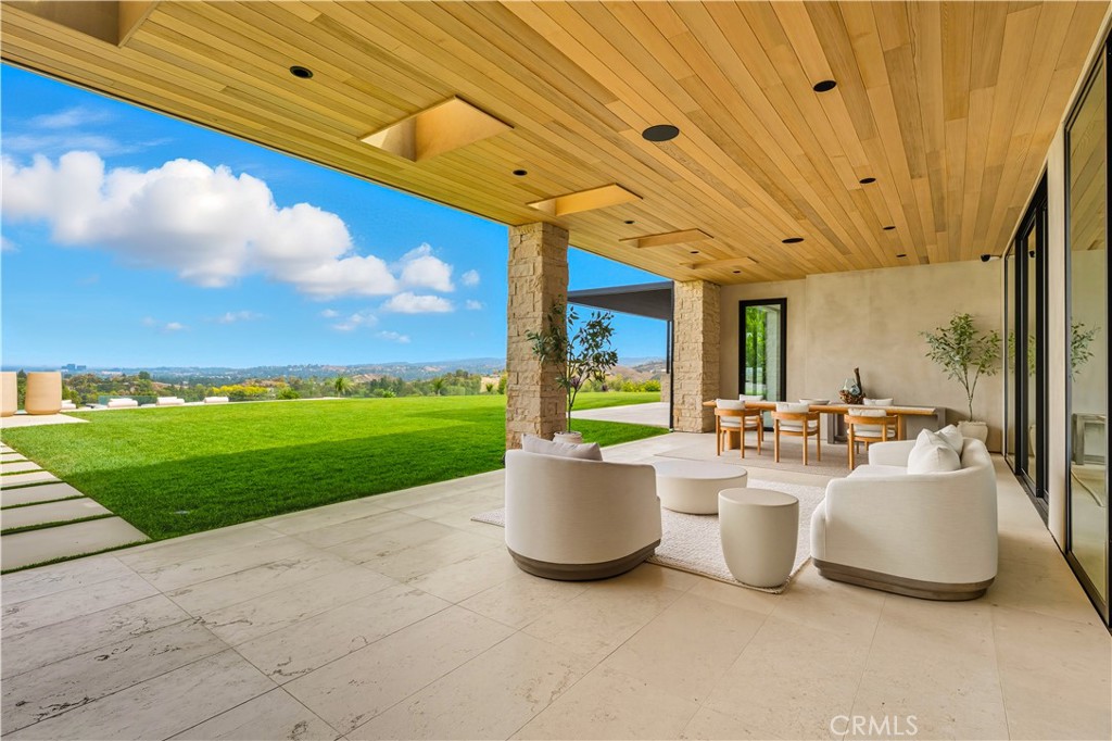 25079 Jim Bridger Road Hidden Hills, CA 91302 - Photo 44 of 73 a view of a patio with table and chairs and garden view