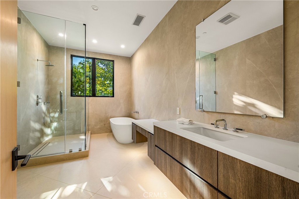 25079 Jim Bridger Road Hidden Hills, CA 91302 - Photo 68 of 73 a bathroom with a double vanity sink large mirror and a shower