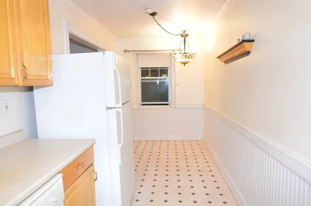 a hallway with a white cabinet a wooden floor and a cabinet