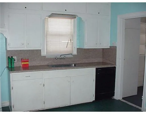a kitchen with granite countertop white cabinets and a sink