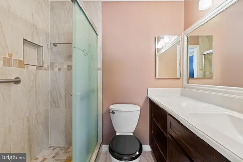 a bathroom with a granite countertop sink toilet and shower