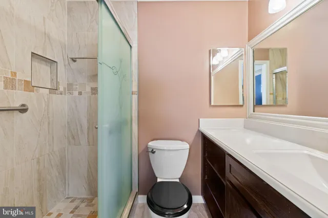 a bathroom with a granite countertop sink toilet and shower