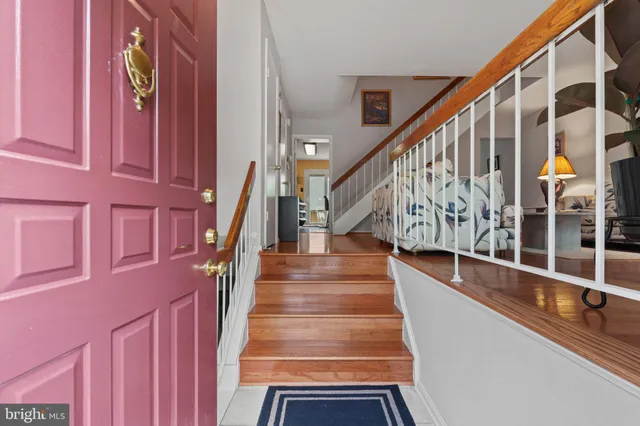 a view of staircase with lots of frames on wall and a windows