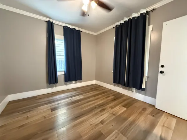 a view of a room with wooden floor and windows