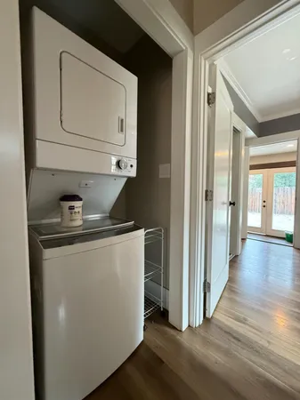 a utility room with wooden floor washer and dryer