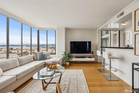 a living room with furniture city view and large windows