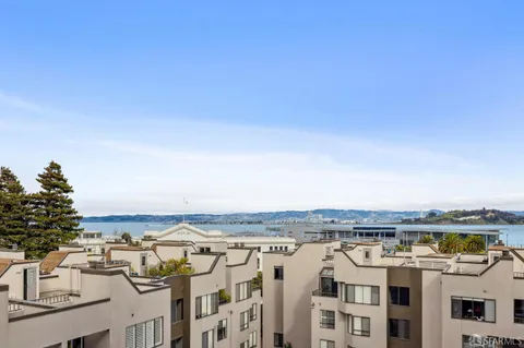 a kitchen with stainless steel appliances granite countertop a refrigerator stove and white cabinets