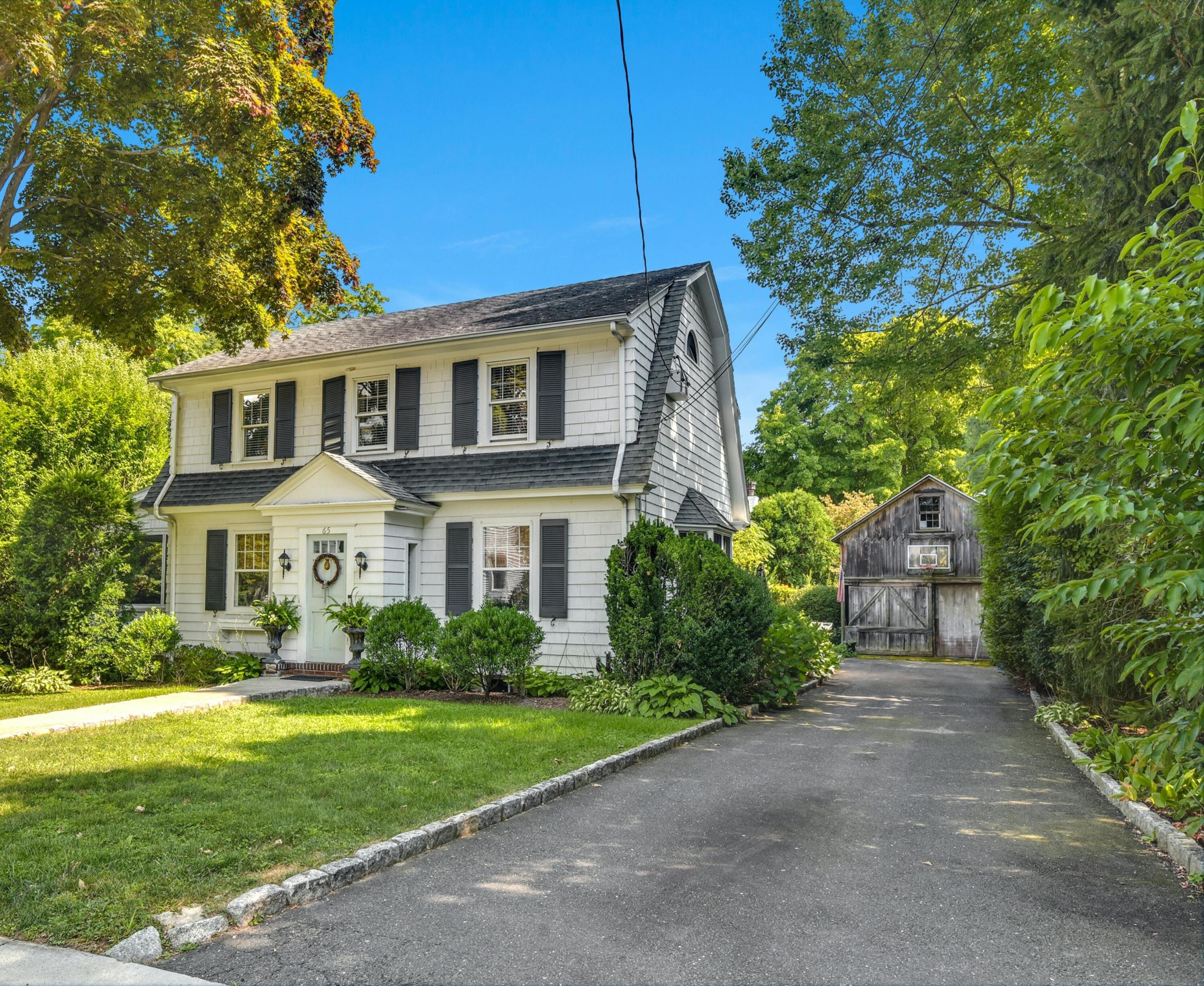 65 Church Street New Canaan, CT 06840 - Photo 1 of 28 a front view of a house with garden