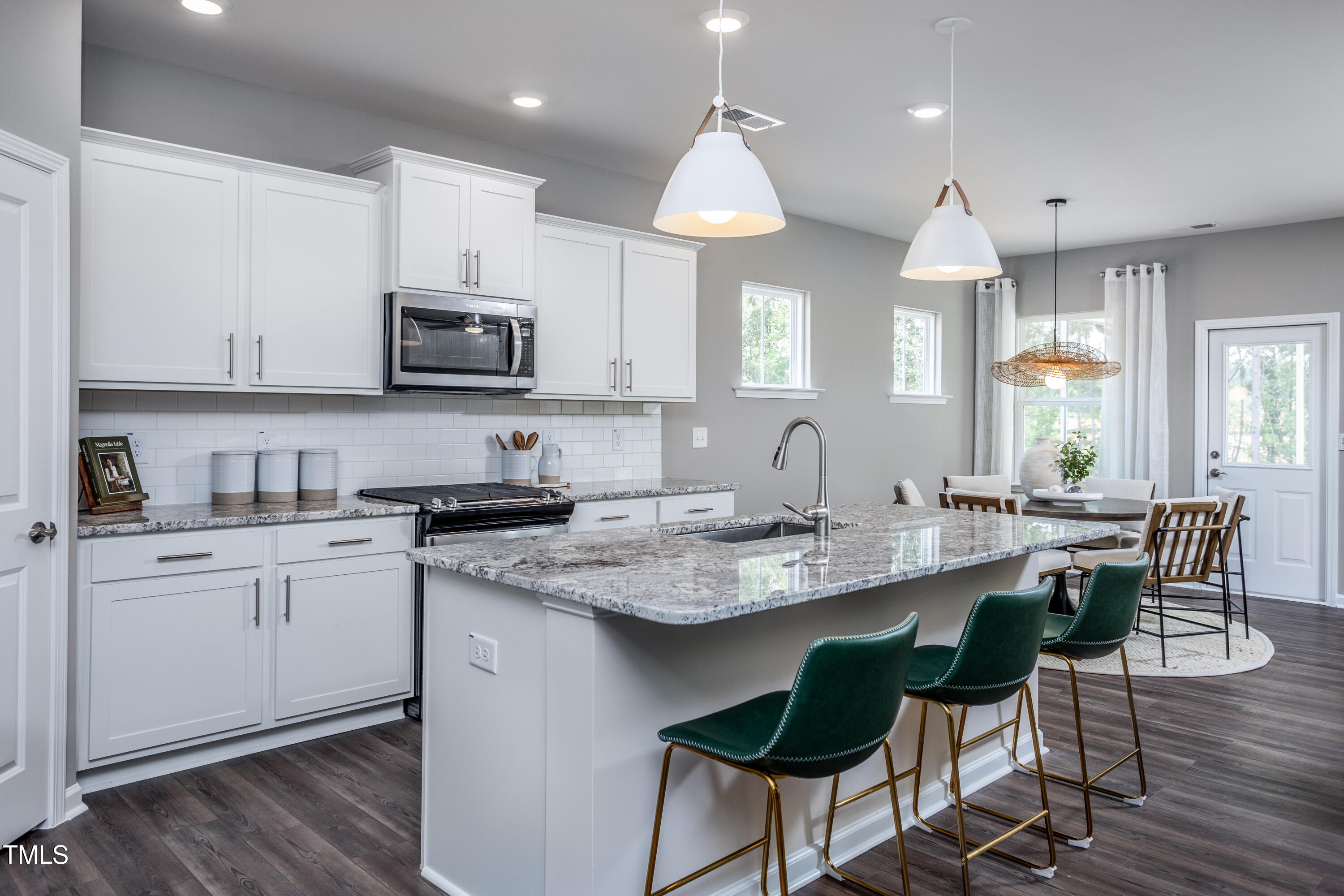773 Denburn Place Raleigh, NC 27603 - Photo 3 of 27 a kitchen with stainless steel appliances granite countertop a sink a stove a microwave a dining table and chairs