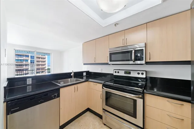 a kitchen with granite countertop a stove microwave and sink