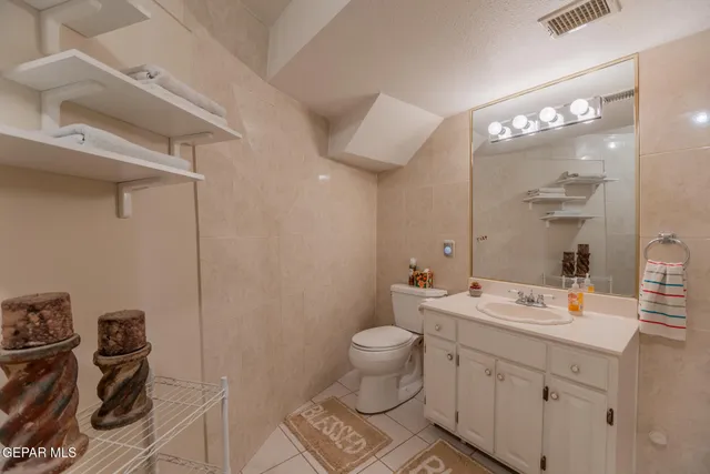 a bathroom with a sink mirror and a toilet