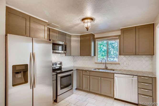 3232 West 28th Avenue Denver, CO 80211 - Photo 2 of 9 a kitchen with stainless steel appliances a refrigerator sink and microwave