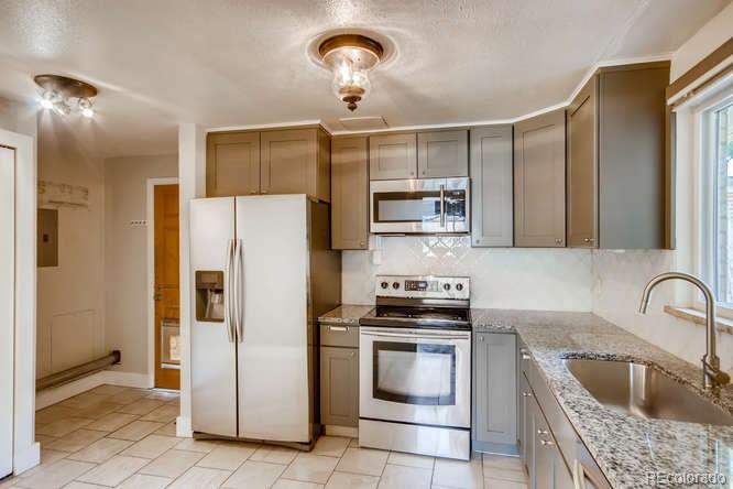 3232 West 28th Avenue Denver, CO 80211 - Photo 5 of 9 a kitchen with stainless steel appliances granite countertop a refrigerator a stove a sink and a microwave