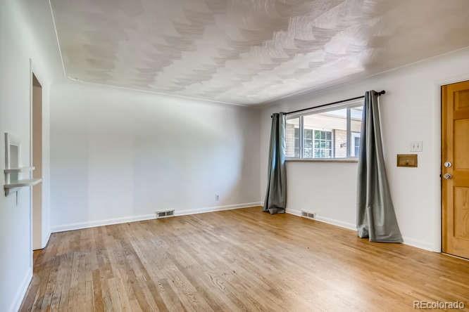 3232 West 28th Avenue Denver, CO 80211 - Photo 6 of 9 an empty room with wooden floor and a window