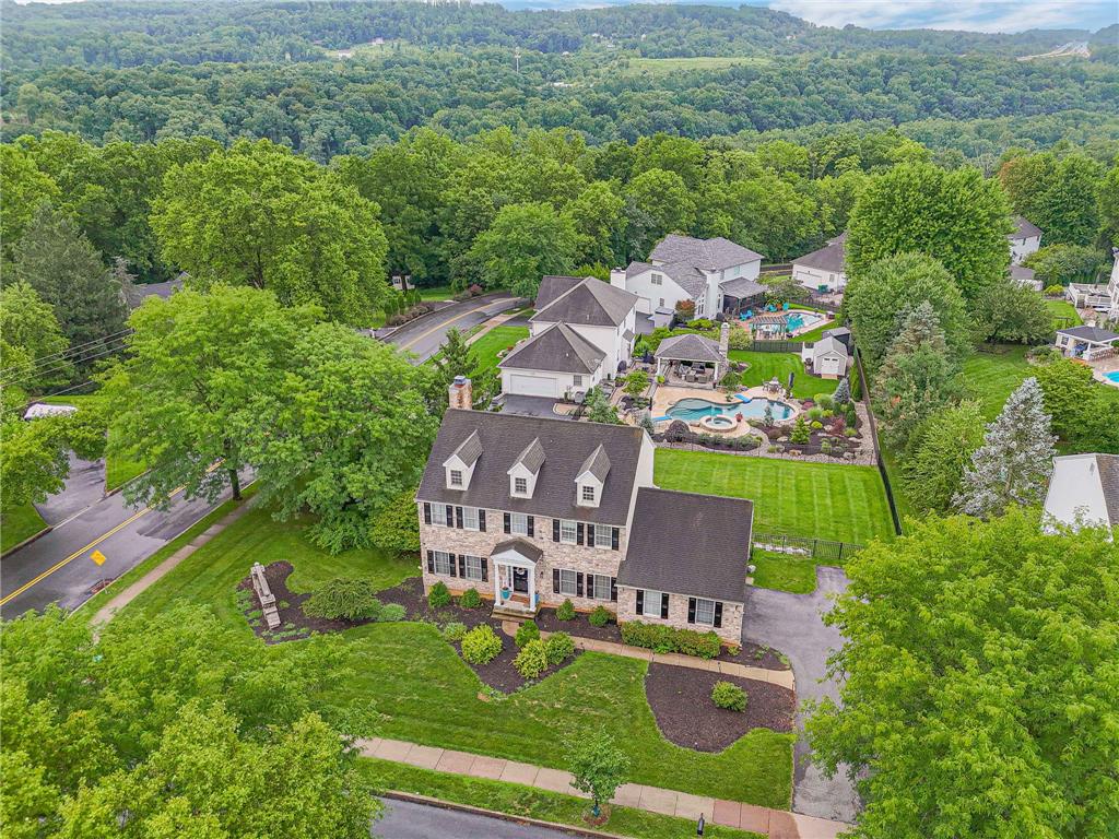 Lush rolling hills frame this stately multi-story brick residence with classic dormer windows.