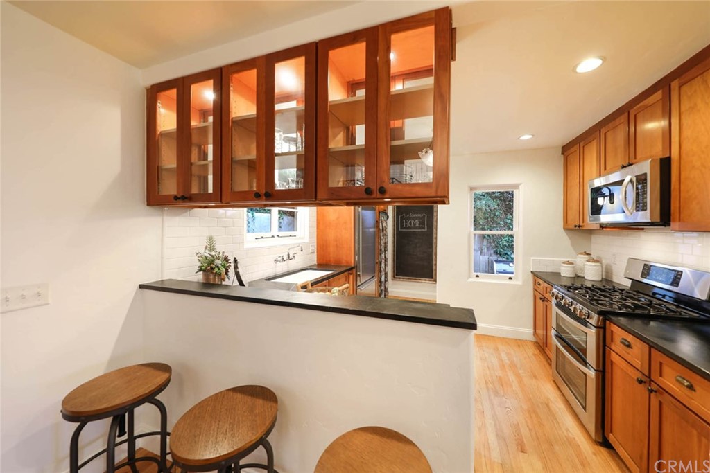 1107 Coast View Drive Laguna Beach, CA 92651 - Photo 12 of 48 a kitchen with a sink a stove and a wooden cabinets