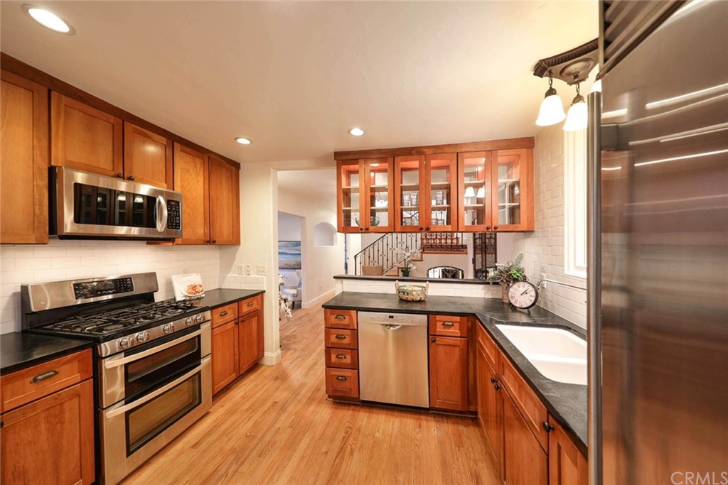 1107 Coast View Drive Laguna Beach, CA 92651 - Photo 13 of 48 a kitchen with stainless steel appliances kitchen island granite countertop a stove a sink and a refrigerator