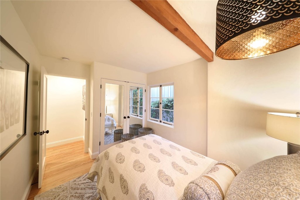 1107 Coast View Drive Laguna Beach, CA 92651 - Photo 20 of 48 a bedroom with a bed a mirror and a large window