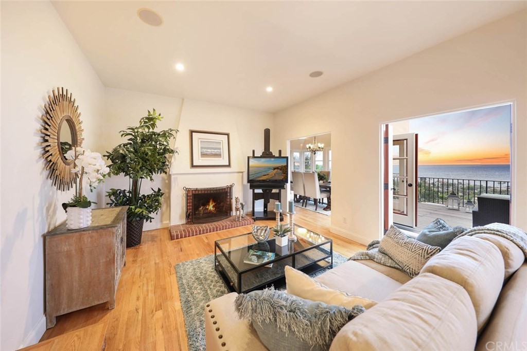 1107 Coast View Drive Laguna Beach, CA 92651 - Photo 24 of 48 a living room with furniture a fireplace and a flat screen tv
