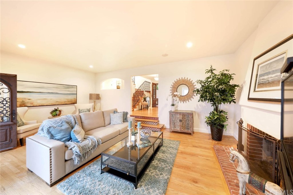 1107 Coast View Drive Laguna Beach, CA 92651 - Photo 25 of 48 a living room with furniture a chandelier and a fireplace