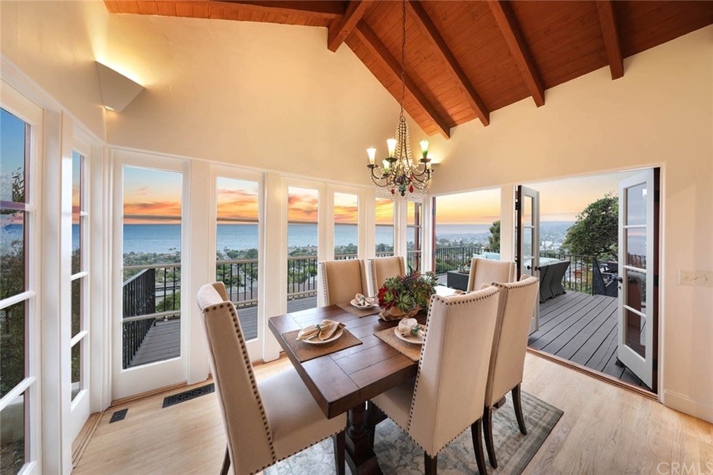 1107 Coast View Drive Laguna Beach, CA 92651 - Photo 26 of 48 a view of a dining room with furniture large windows and wooden floor