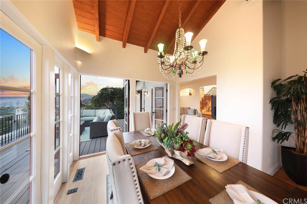 1107 Coast View Drive Laguna Beach, CA 92651 - Photo 27 of 48 a view of a dining room with furniture a chandelier and wooden floor