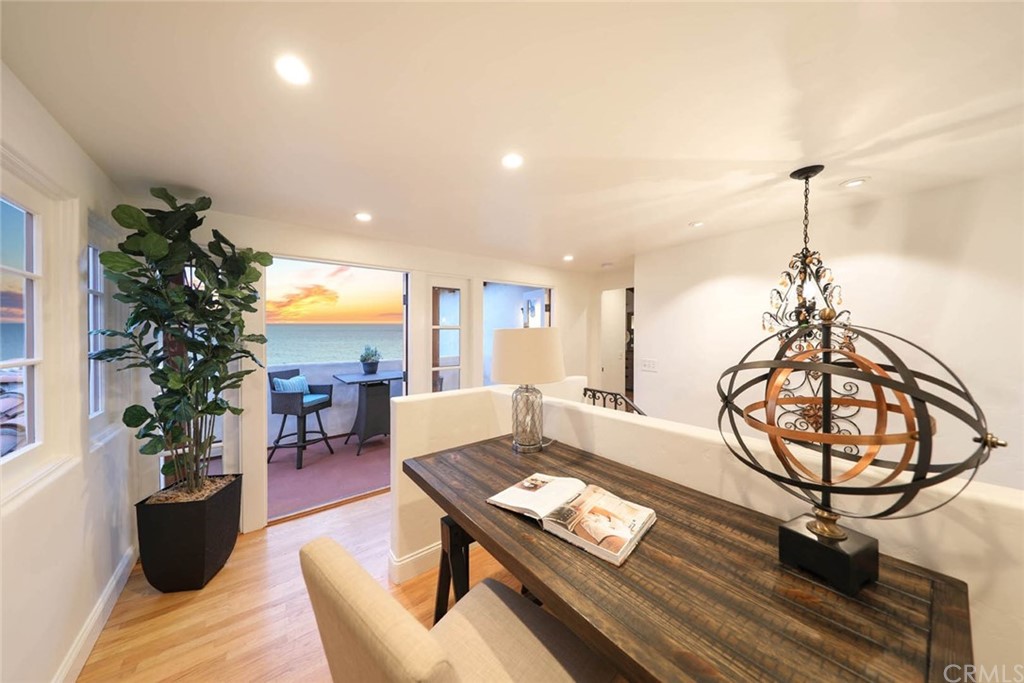 1107 Coast View Drive Laguna Beach, CA 92651 - Photo 28 of 48 a living room with furniture a chandelier and a wooden floor