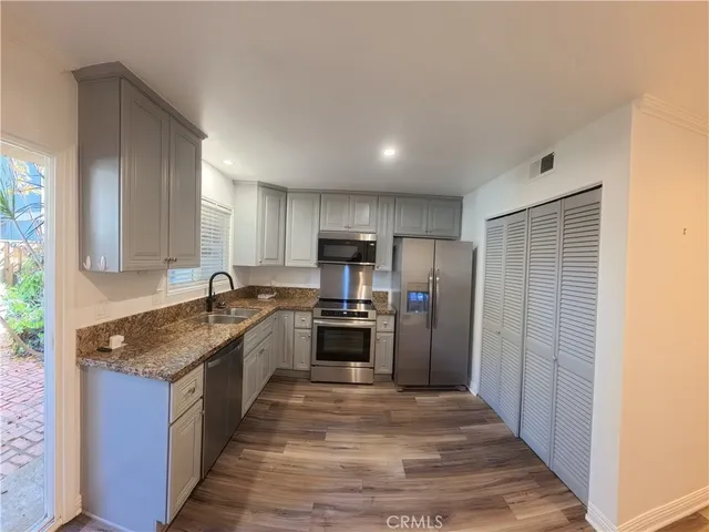 a large kitchen with stainless steel appliances granite countertop a refrigerator and a sink