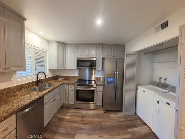 a kitchen with stainless steel appliances granite countertop a sink stove and refrigerator