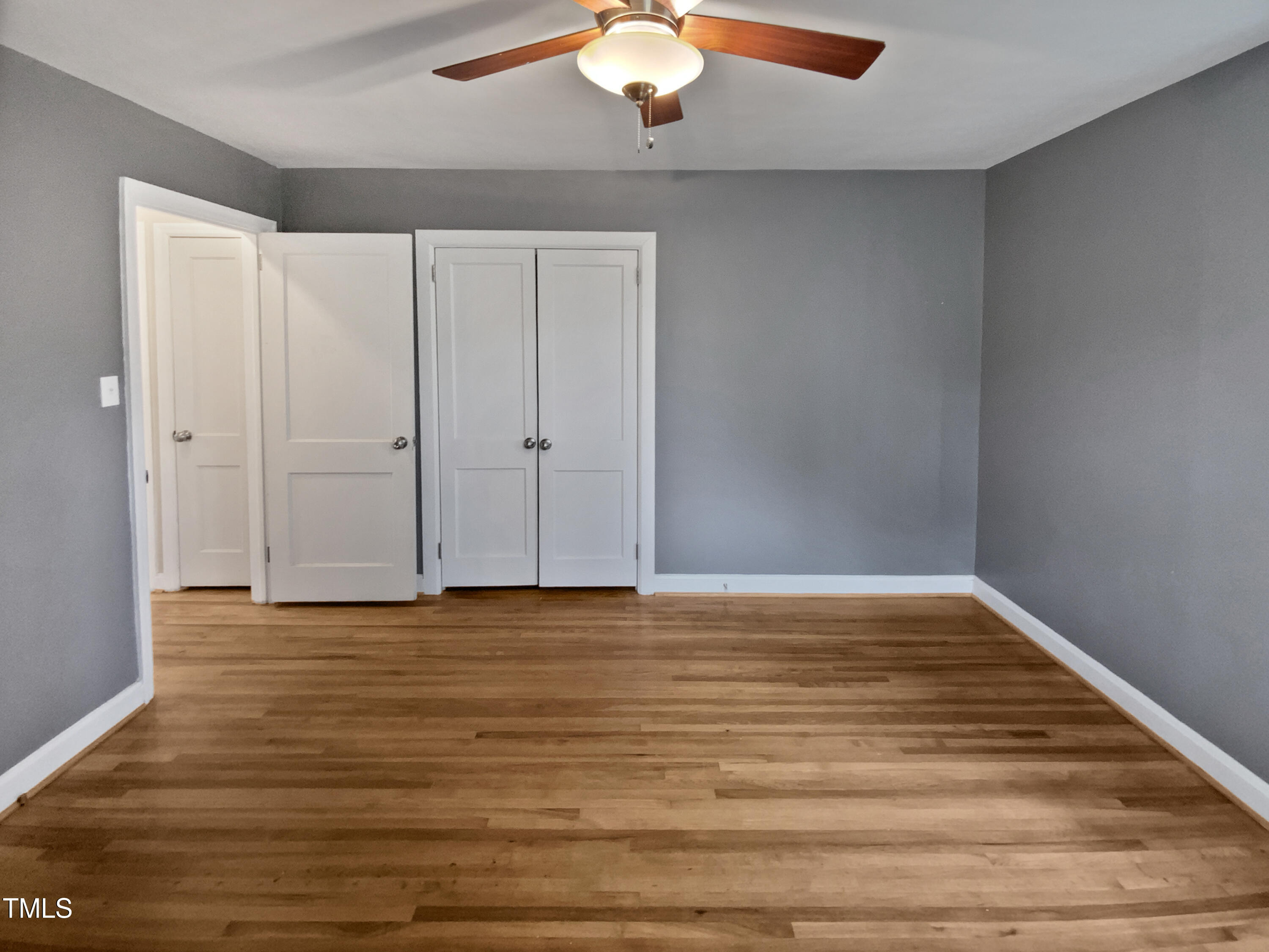 802 Powell Drive Garner, NC 27529 - Photo 12 of 17 a view of an empty room with wooden floor and a window