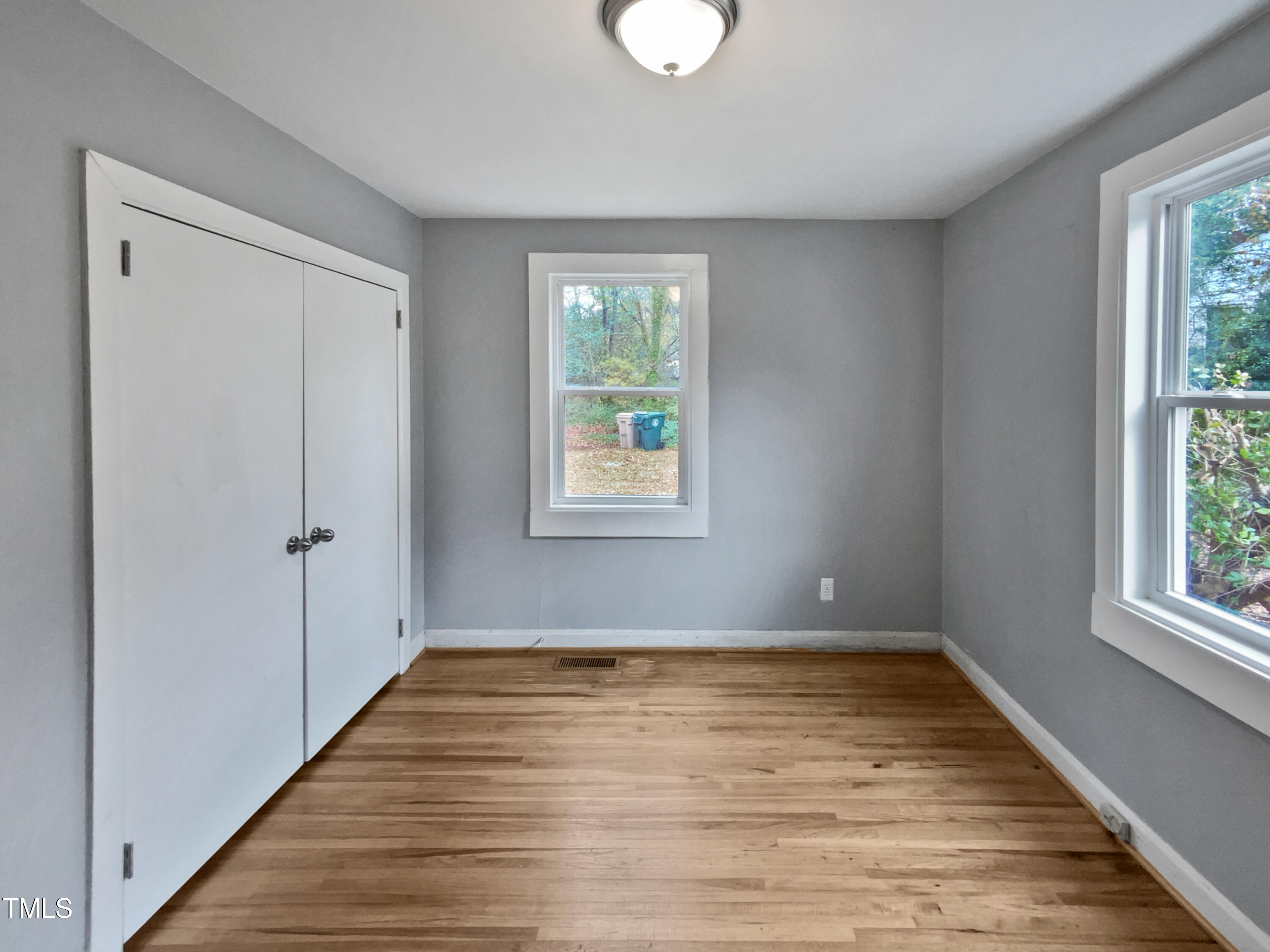 802 Powell Drive Garner, NC 27529 - Photo 13 of 17 a view of an empty room with wooden floor and a window