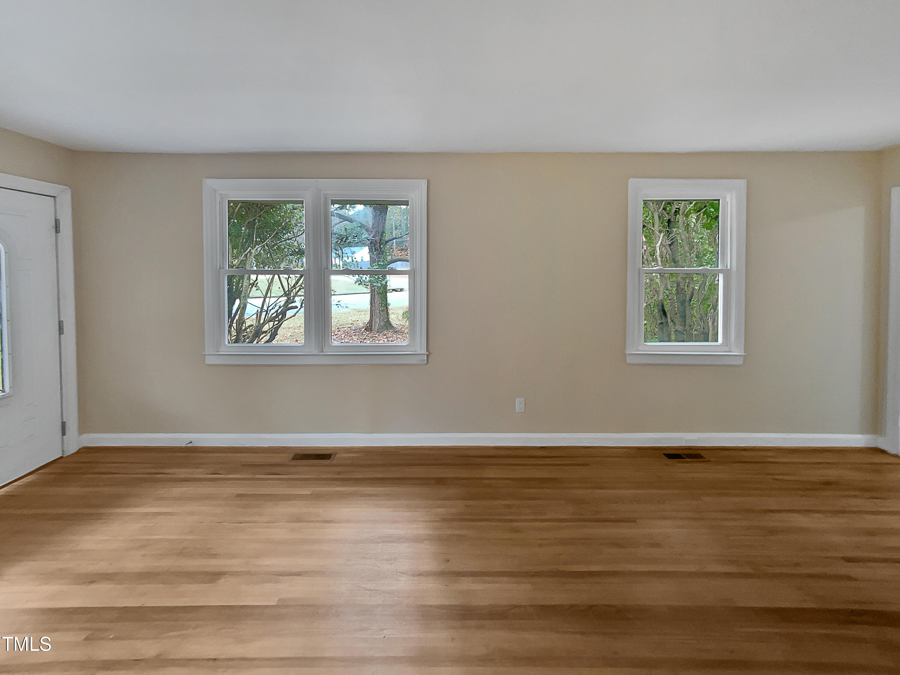 802 Powell Drive Garner, NC 27529 - Photo 15 of 17 a view of an empty room with wooden floor and a window
