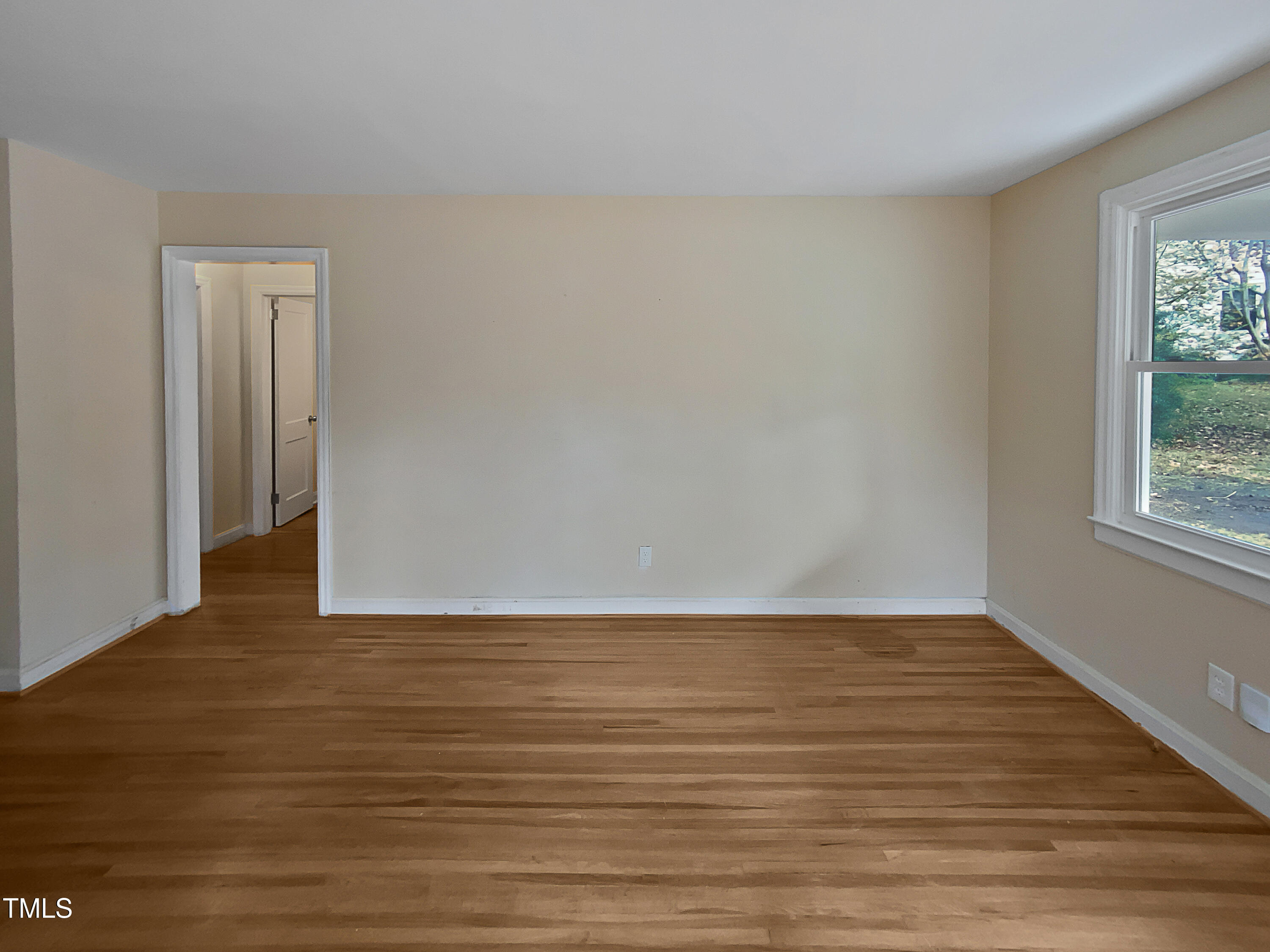 802 Powell Drive Garner, NC 27529 - Photo 5 of 17 a view of an empty room with wooden floor and a window