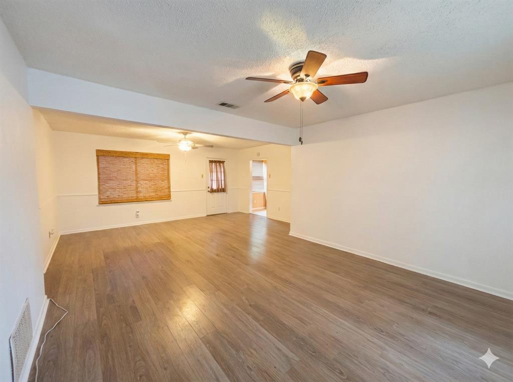 1822 Finley Road Irving, TX 75062 - Photo 6 of 14 a view of a big room with wooden floor and windows in a room