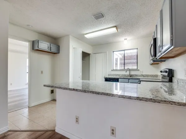 a kitchen with stainless steel appliances granite countertop a sink and a granite counter tops