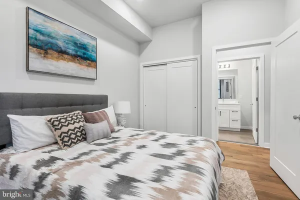 a bedroom with a bed and a painting on the wall