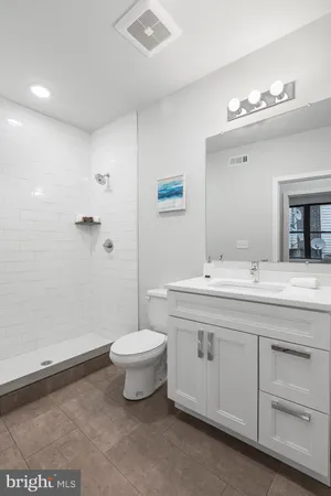 a bathroom with a double vanity sink a toilet and a mirror