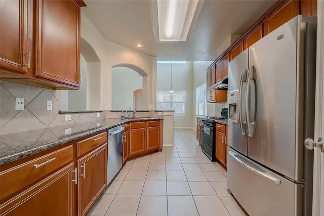 a kitchen with stainless steel appliances granite countertop a refrigerator and a sink