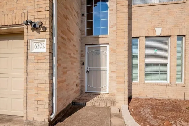 a view of a brick house with a window and a door