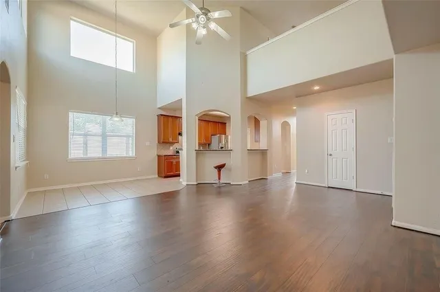 a view of an empty room with window and wooden floor