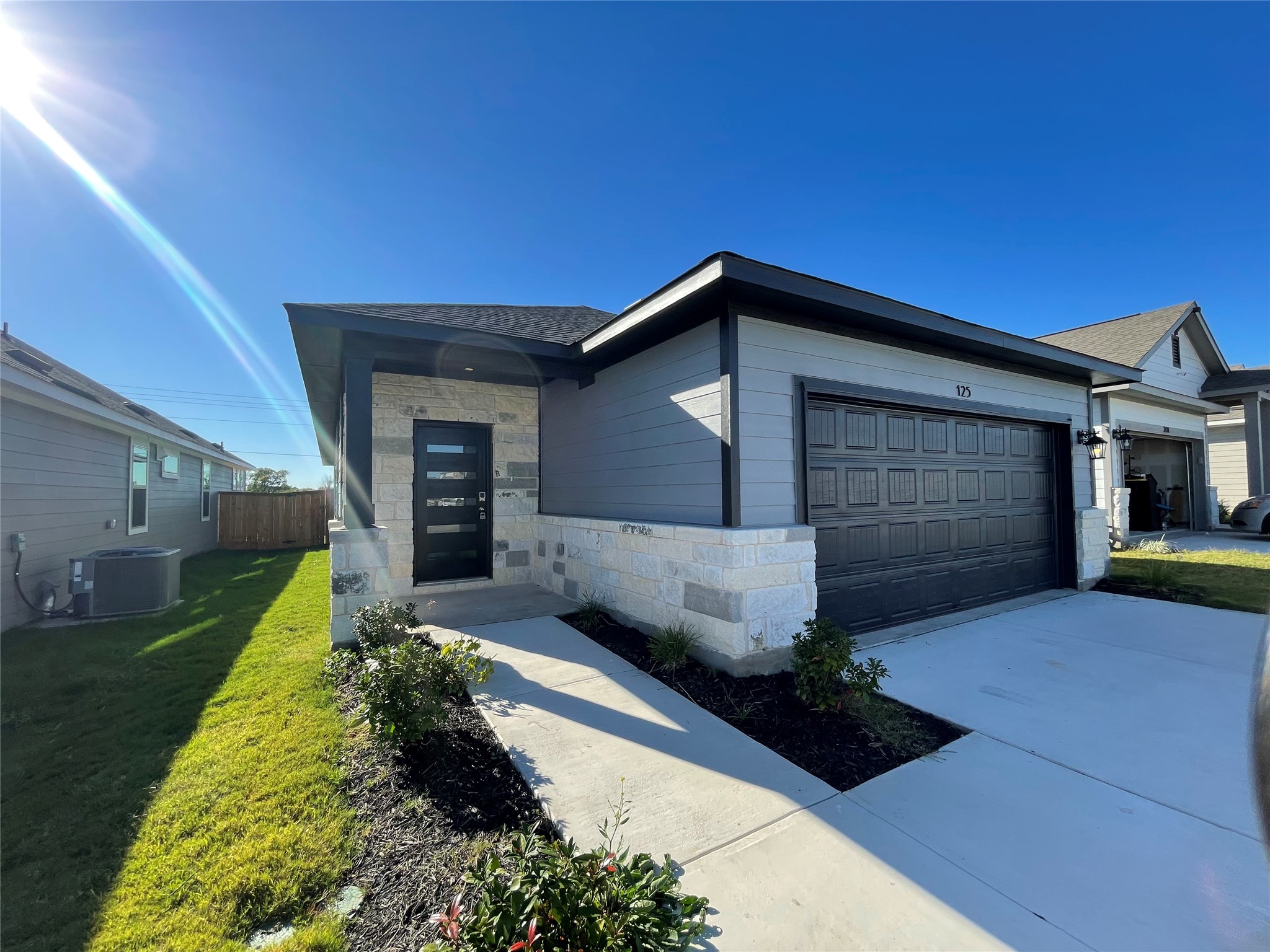 View of front of property with stone siding, a garage, and concrete driveway