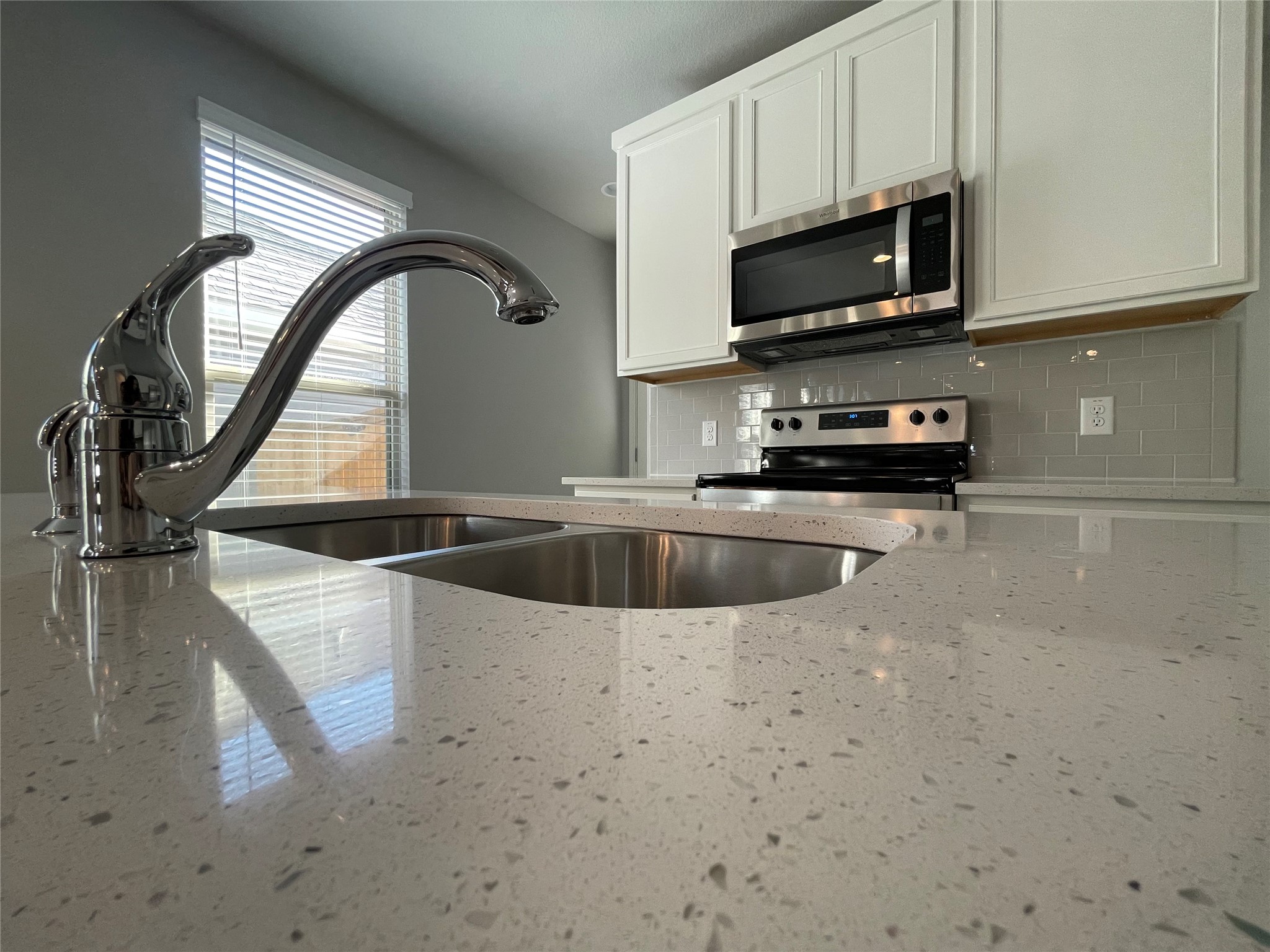 125 Unforgiven Lane Jarrell, TX 76537 - Photo 6 of 17 Kitchen featuring stainless steel appliances, light stone countertops, white cabinetry, and decorative backsplash