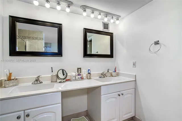 a bathroom with double sink and a mirror