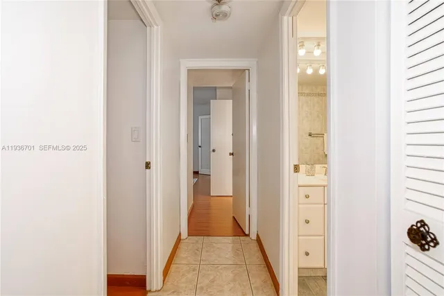 a view of a hallway with closet and a bathroom