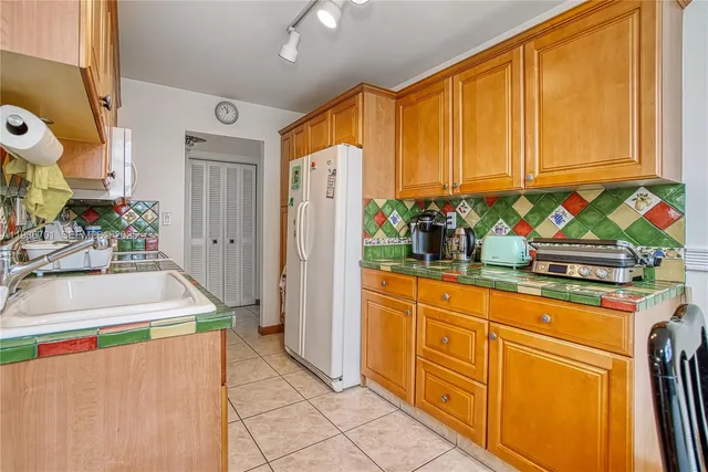 a room with stainless steel appliances granite countertop a refrigerator and cabinets