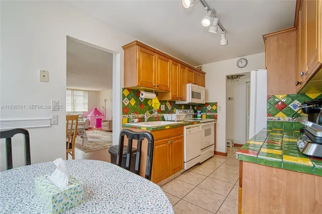 a kitchen with stainless steel appliances granite countertop a stove a sink dishwasher and a refrigerator with wooden floor