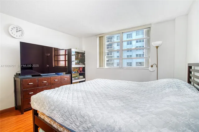 a bedroom with a large bed and a flat screen tv